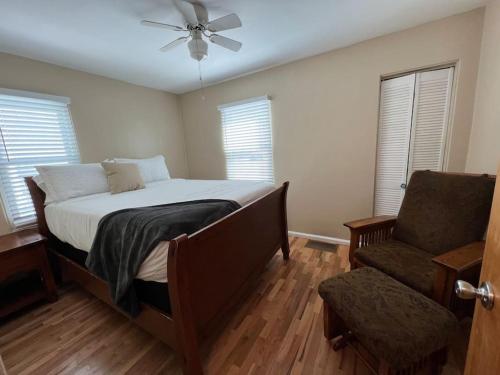 比林斯Snug, neighborly home perfect for your small group的一间卧室配有一张床、一把椅子和吊扇