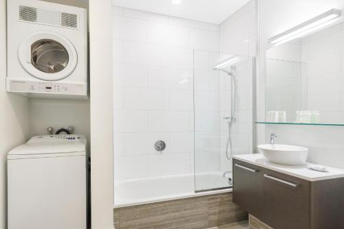 惠灵顿惠灵顿城市生活酒店的白色的浴室设有水槽和洗衣机。