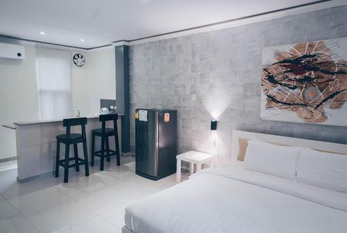 邦劳阿罗那北国度假酒店 的一间卧室配有一张床,酒吧配有凳子