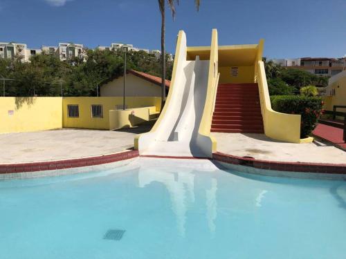 法哈多Casa Rosado @ Villa Marina Fajardo Pool Yunque的大楼内一个带滑梯的游泳池