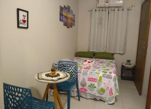 因比图巴Praia do Rosa loft com cozinha的卧室配有一张床和一张桌子及椅子