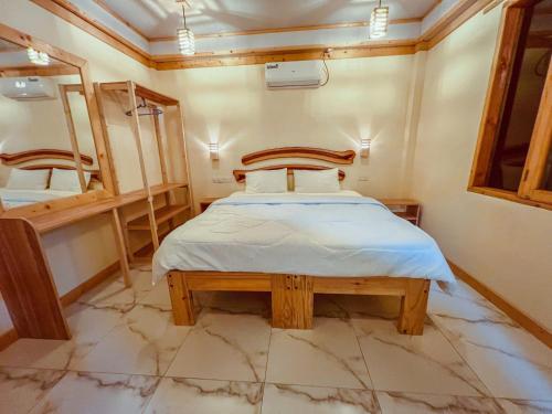 希曼杜岛Black Pearl Himandhoo的一间小卧室,配有一张床和镜子