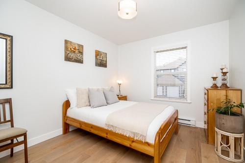 兰利Comfortable and Modern Rowhouse Perfect for BC Escapade, air conditioned的白色的卧室设有床和窗户