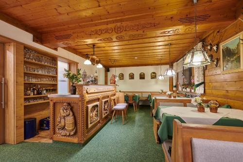 贝希特斯加登Gästehaus Sonnenbichl的餐厅设有桌椅和木制天花板。