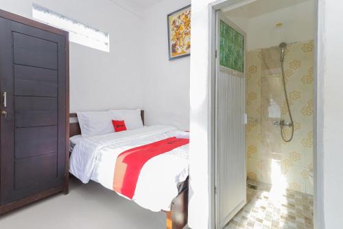 任抹RedDoorz Syariah near Universitas Jember的一间白色卧室,配有床和一间浴室
