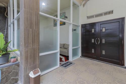 任抹RedDoorz Syariah near Universitas Jember的走廊上的门和沙发