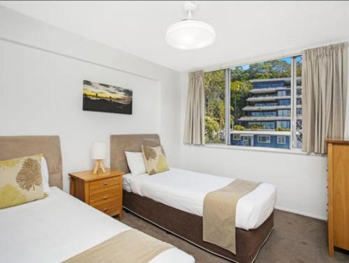 黄金海岸Park Towers Holiday Units的酒店客房设有两张床和窗户。