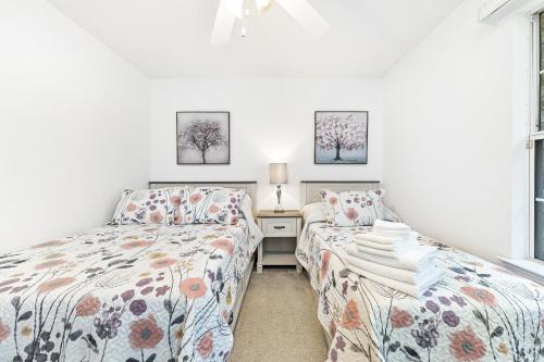 佩尔迪多海滩Charming Pensacola House with All Needed Essentials的一间卧室设有两张床、一张桌子和两个窗户。