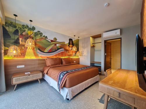 纳闽巴霍Parlezo by Kagum Hotels的卧室配有一张床,墙上挂有绘画作品