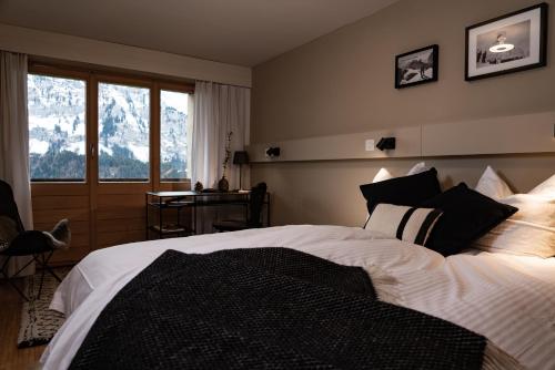 英格堡VILLA HUNDERT Boutique Mountainscape的一间卧室配有一张床、一张书桌和一个窗户。