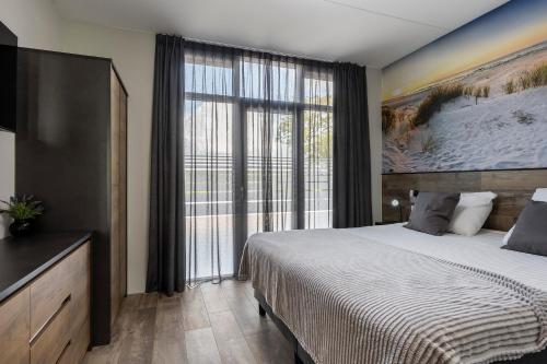 诺德韦克Holiday Apartment Strand的一间卧室设有一张大床和一个大窗户