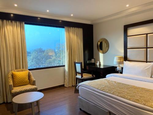 哈里瓦Fortune Park, Haridwar - Member ITC's Hotel Group的配有一张床、一张书桌和一扇窗户的酒店客房