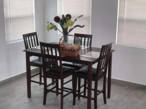 DonoeLeona's Hidden Adventure home的餐桌、椅子和一篮鲜花