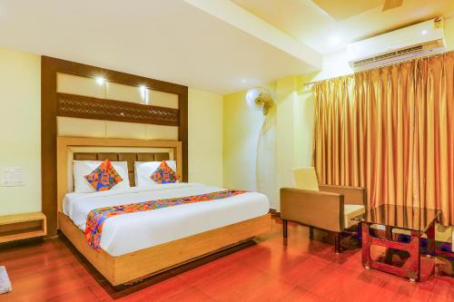 维杰亚瓦达FabHotel Keerthi's Anupama Governor Peta的一间卧室配有一张大床、一张桌子和一张书桌