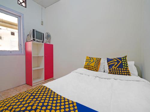 PadalarangSPOT ON 91993 Pondok Hs Padalarang Syariah的一间卧室配有黄色和蓝色枕头的床