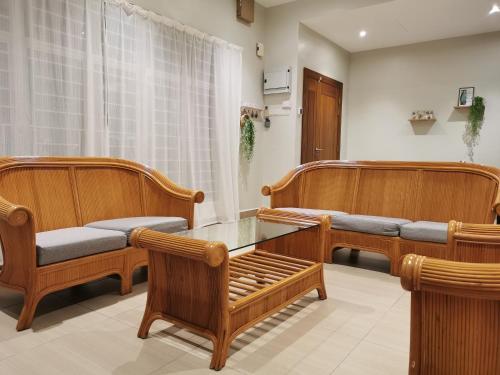 马六甲28 Residence Homestay的一间设有木长椅和桌子的等候室