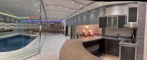 哈伊勒شاليه ريست 1的厨房和带游泳池的客厅