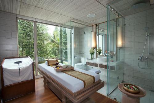 Padalarang万隆梅森青松酒店的浴室设有床铺和玻璃淋浴间。