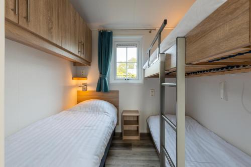 Biggekerke斯特朗营地瓦尔肯斯酒店的小房间设有两张双层床和窗户