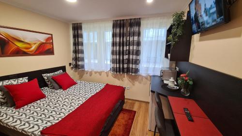 莫雄马扎尔古堡Lucsony Apartman的一间卧室配有一张带红色枕头的床和一台电视。