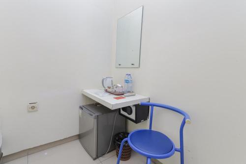 泗水RedDoorz Plus At K23 Rungkut Madya的房间里的水槽旁边有一个蓝色凳子