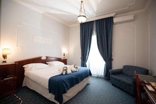 孔图尔西泰尔梅罗莎佩佩酒店的配有一张床和一把椅子的酒店客房