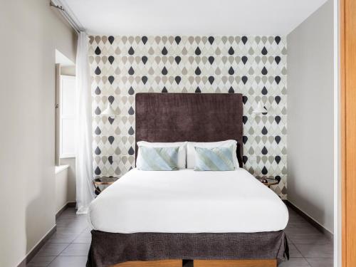 罗马numa I Vici Rooms & Apartments的卧室配有一张白色大床和一堵墙