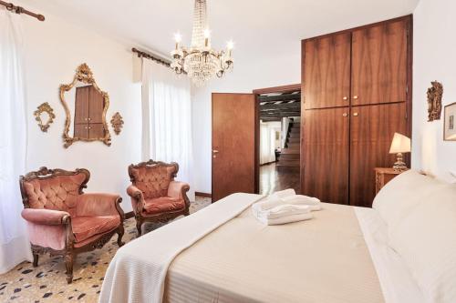 威尼斯San Marco Bell Tower House的一间卧室配有一张床和两把椅子
