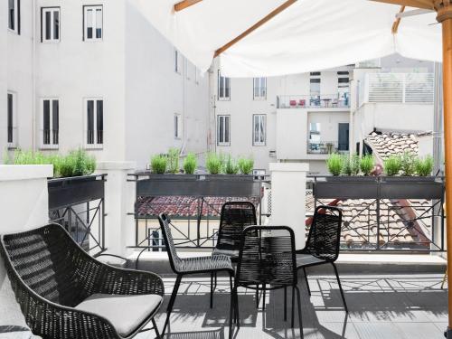 罗马numa I Vici Rooms & Apartments的阳台上的一组桌椅