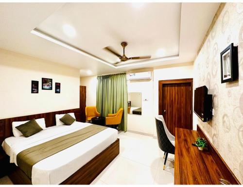 BīdarSagar Regency And Lodge, Bidar的一间卧室配有一张床、一张书桌和一台电视