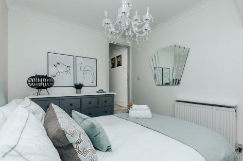 亨利昂泰晤士Central Hidden Gem的卧室配有白色的床和吊灯。