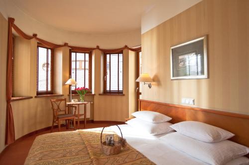 格丁尼亚薇拉卢比奇酒店的一间卧室配有两张床和一张桌子及椅子
