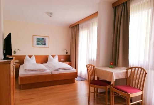 圣卡尼兹Strandpension Liane的酒店客房带一张床、一张桌子和椅子