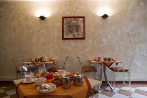 帕多瓦阿尔法贾诺艺术酒店的用餐室配有2张桌子和食物
