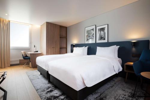 尼斯Radisson Hotel Nice Airport的卧室配有一张白色大床和蓝色的墙壁