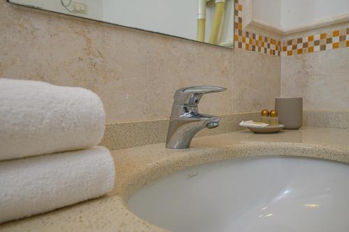 坎普码头伊尔巴玛莉娜迪坎普酒店的浴室配有水槽、水龙头和毛巾