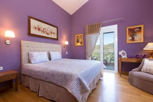 AmbelákionVilla Kleanthi的一间卧室设有紫色的墙壁、一张床和一张沙发