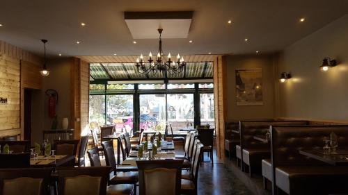 拉尔让蒂埃拉贝塞埃Hôtel Restaurant Glaizette的一间带桌椅和吊灯的用餐室