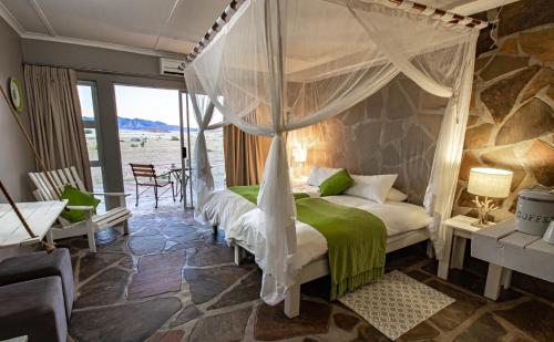 塞斯瑞姆Elegant Desert Lodge的一间卧室配有一张带天蓬的床