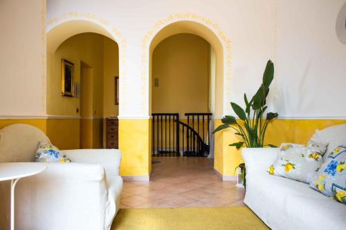 陶尔米纳Badia Holiday Home的客厅配有2张白色沙发和植物