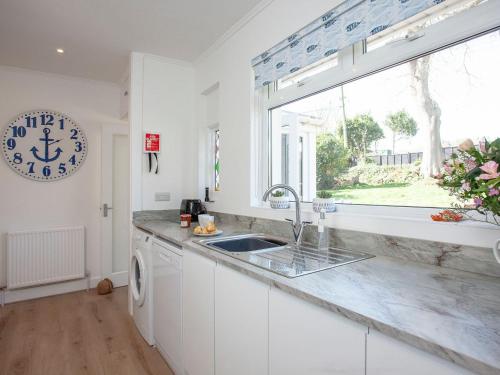 锡德茅斯Blue Horizon的白色的厨房设有水槽和窗户