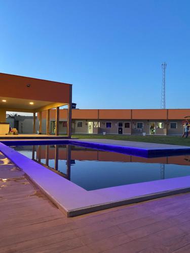 圣阿马鲁Pousada Vila das Lagoas的一座建筑物顶部的游泳池,上面有蓝色的灯光