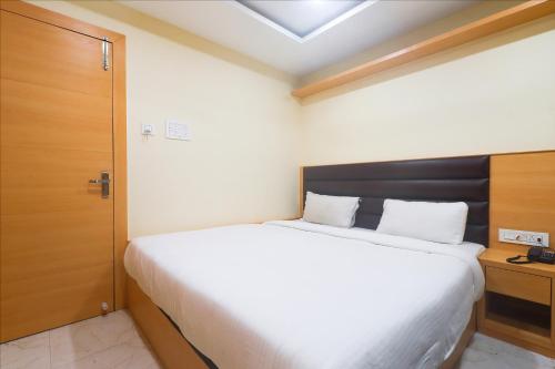西里古里FabExpress Ganpati 2的卧室配有一张白色大床和木门