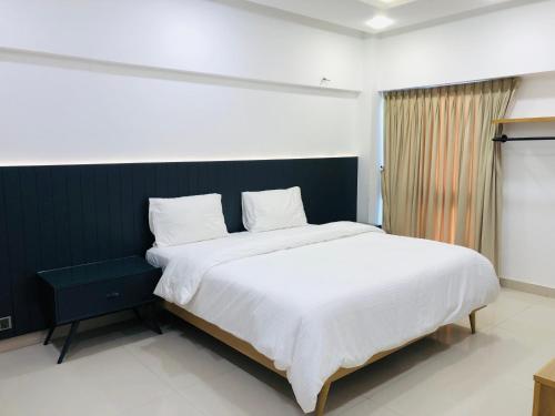 卡拉奇Hamsun Apart Hotel Clifton的一间卧室配有一张带白色床单的大床