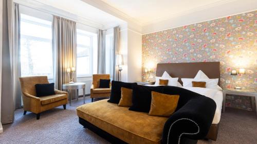 塞恩德Parkhotel Bilm im Glück am Stadtrand Hannovers的酒店客房,配有床和沙发