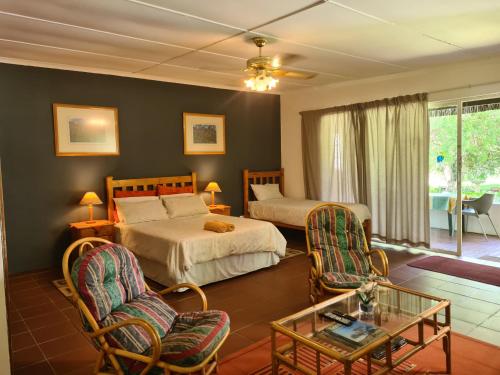 帕雷斯Otters' Haunt Eco Retreat的一间卧室配有两张床和一张桌子及椅子