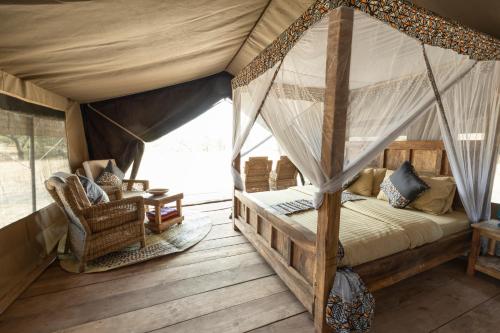 SinoniAfrica Safari South Serengeti Ndutu Ngorongoro的一间帐篷内带天蓬床的卧室