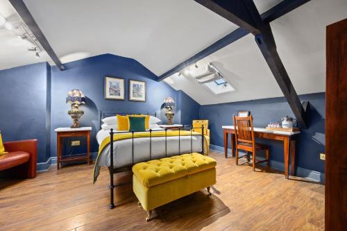约克The Fat Badger York的一间卧室设有蓝色的墙壁、一张床和一张书桌