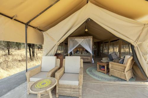 SinoniAfrica Safari South Serengeti Ndutu Ngorongoro的帐篷配有两把椅子和一张桌子