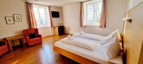 多瑙河畔克雷姆斯Wirtshaus Leindl的一间卧室配有一张带白色床单的床和两个窗户。